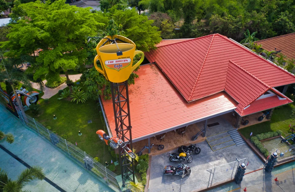 The café from above: the red tiled roof, the garden and the steel tower with a giant coffee cup on top